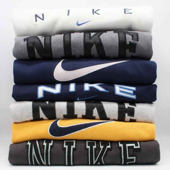 Lot de sweatshirts Nike vintage pliés par couleurs et logos
